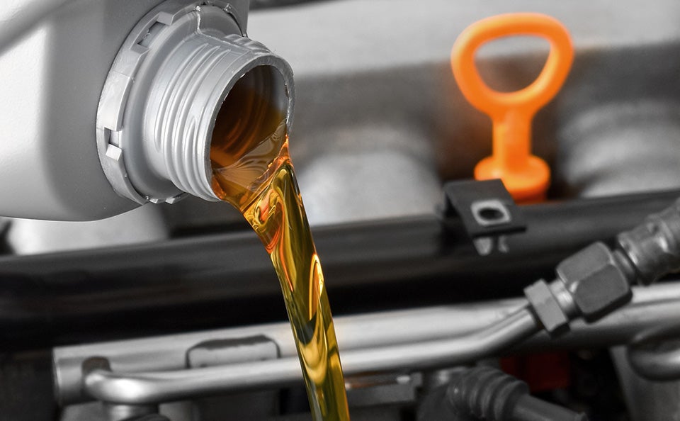 Motor oil being poured into a car’s engine.